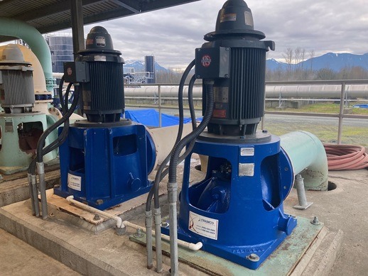 Industrial pumps in action with mountains in the background.